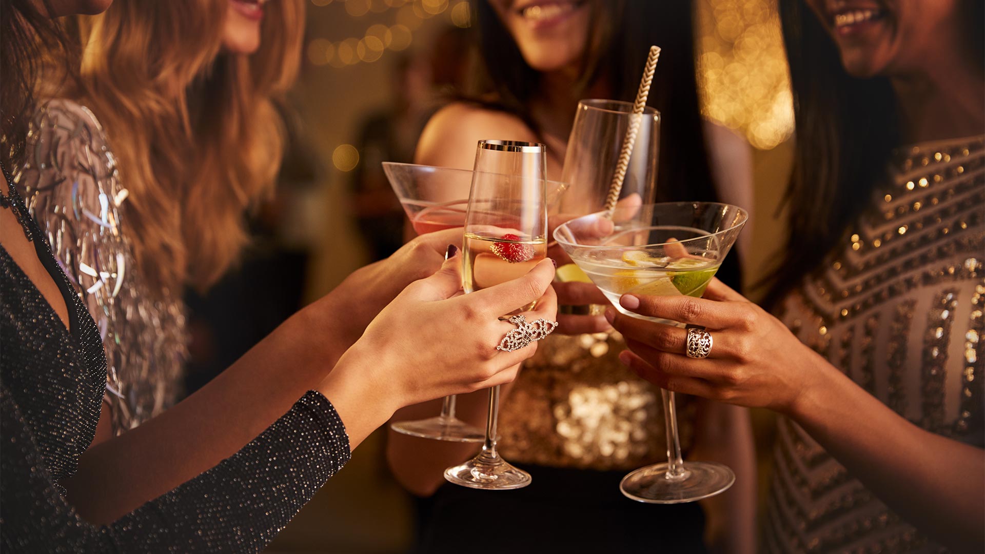 Women clicking glasses of cocktails and champagnes in a bar for after work drinks