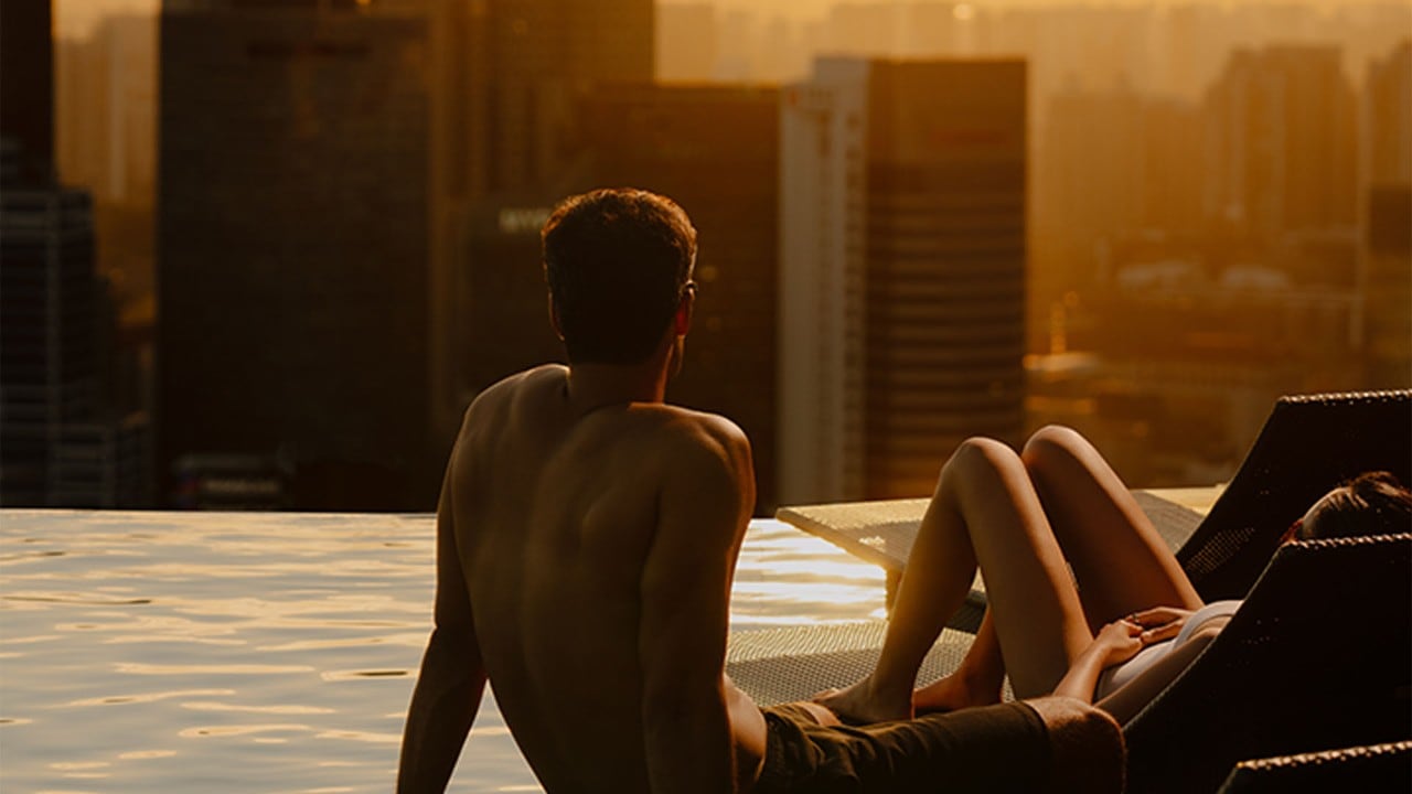 Two guests lounging during sundown at the Infinity Pool at Marina Bay Sands