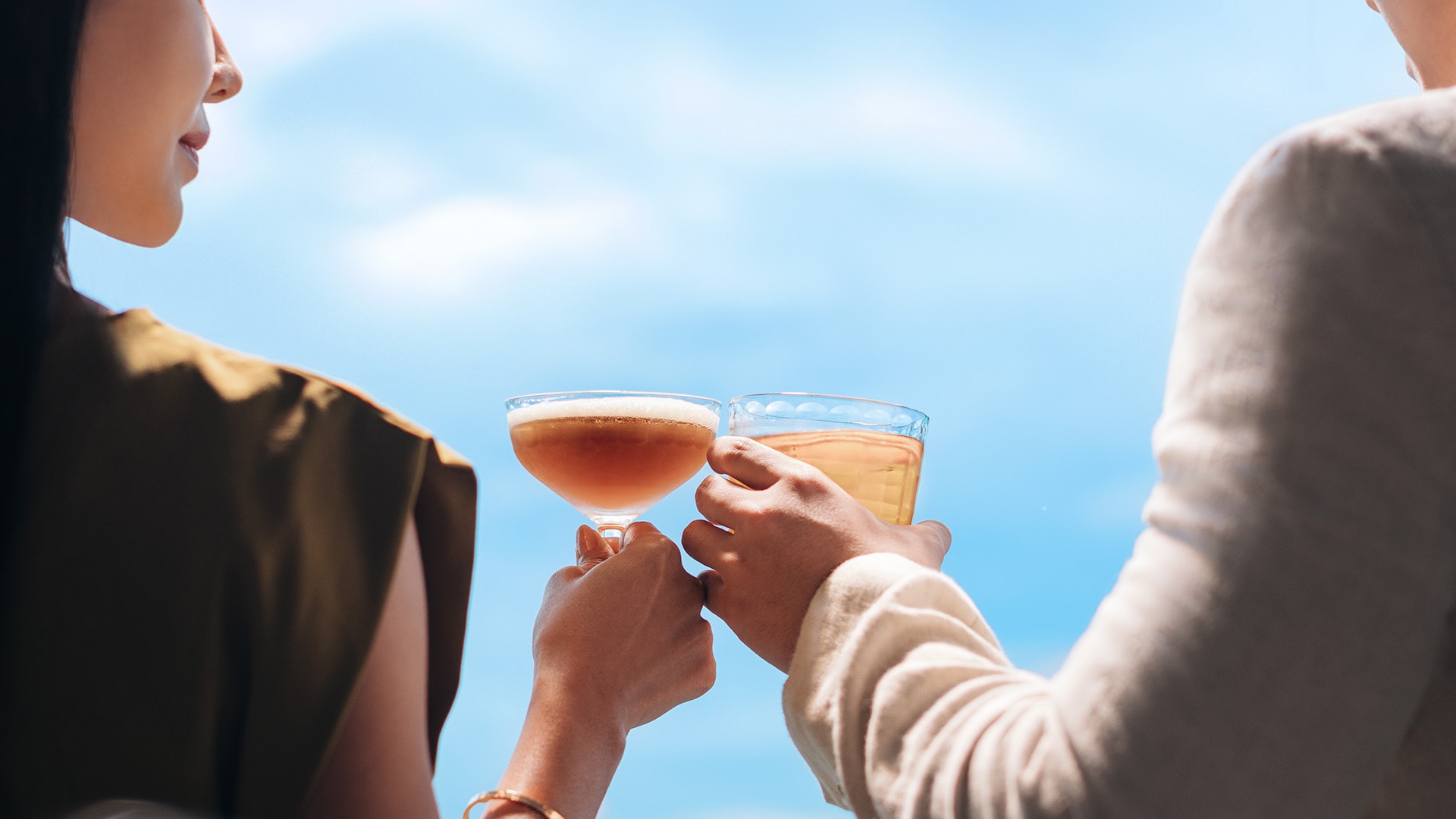 Couple clinking glasses at a rooftop bar to countdown to 2026