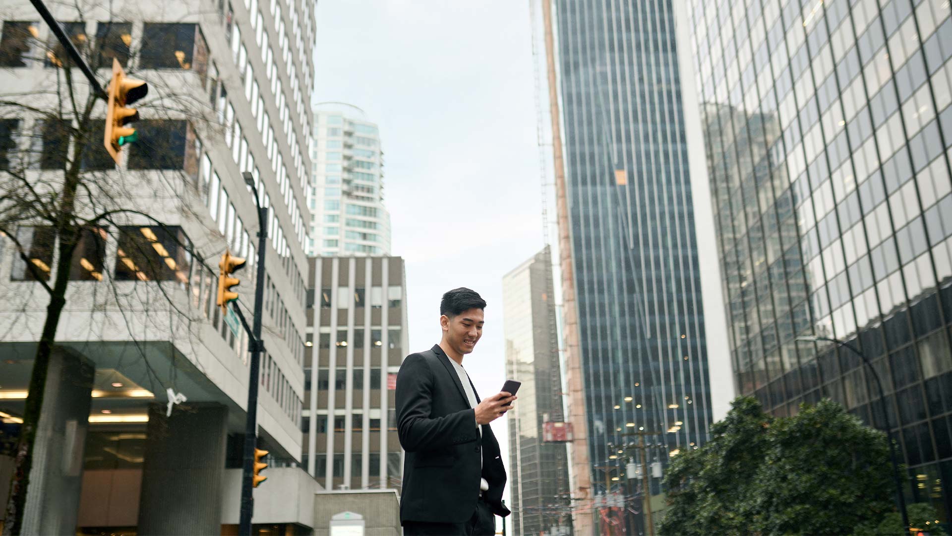 Man in a suit, looking at his smartphone, a tech gadget