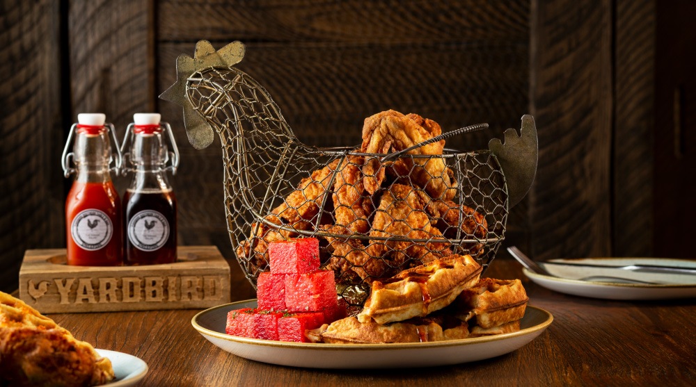 Fried chicken, watermelon and waffles placed in a chicken shaped basket, making it an instagrammable dish at Yardbird