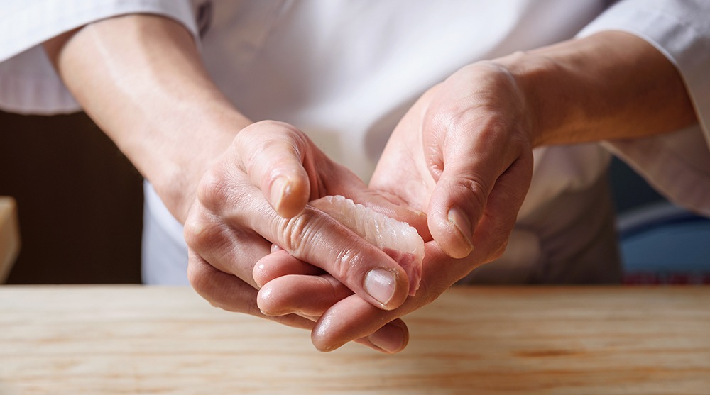 Chef preparing omakase nigiri sushi bare hands