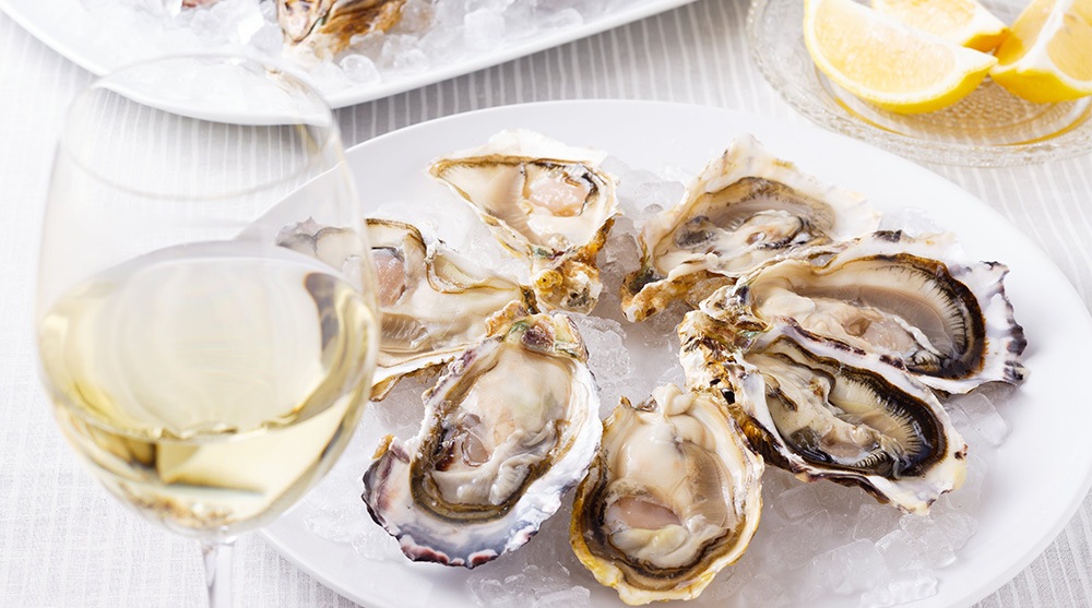Fresh oysters paired with white wine at the best wine bar in Singapore