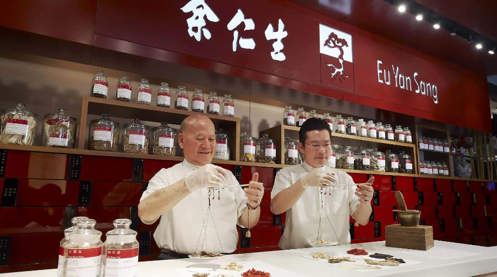 Man weighing supplements and herbs to get for Mother's Day gift from Eu Yan Sang