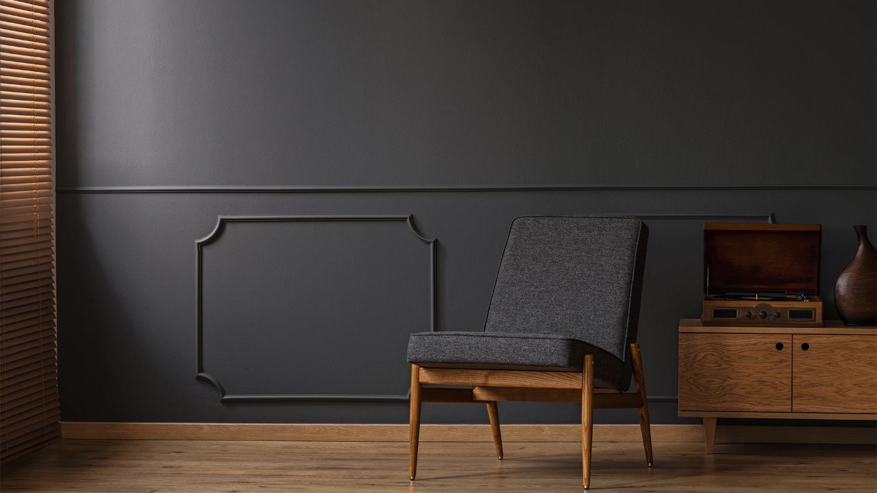Black armchair against a black wall
