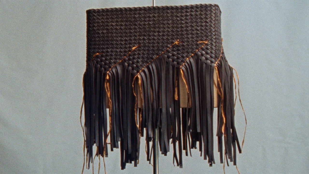 Brown shoulder bag with interwoven patterns from a luxury bag brand, Bottega Veneta