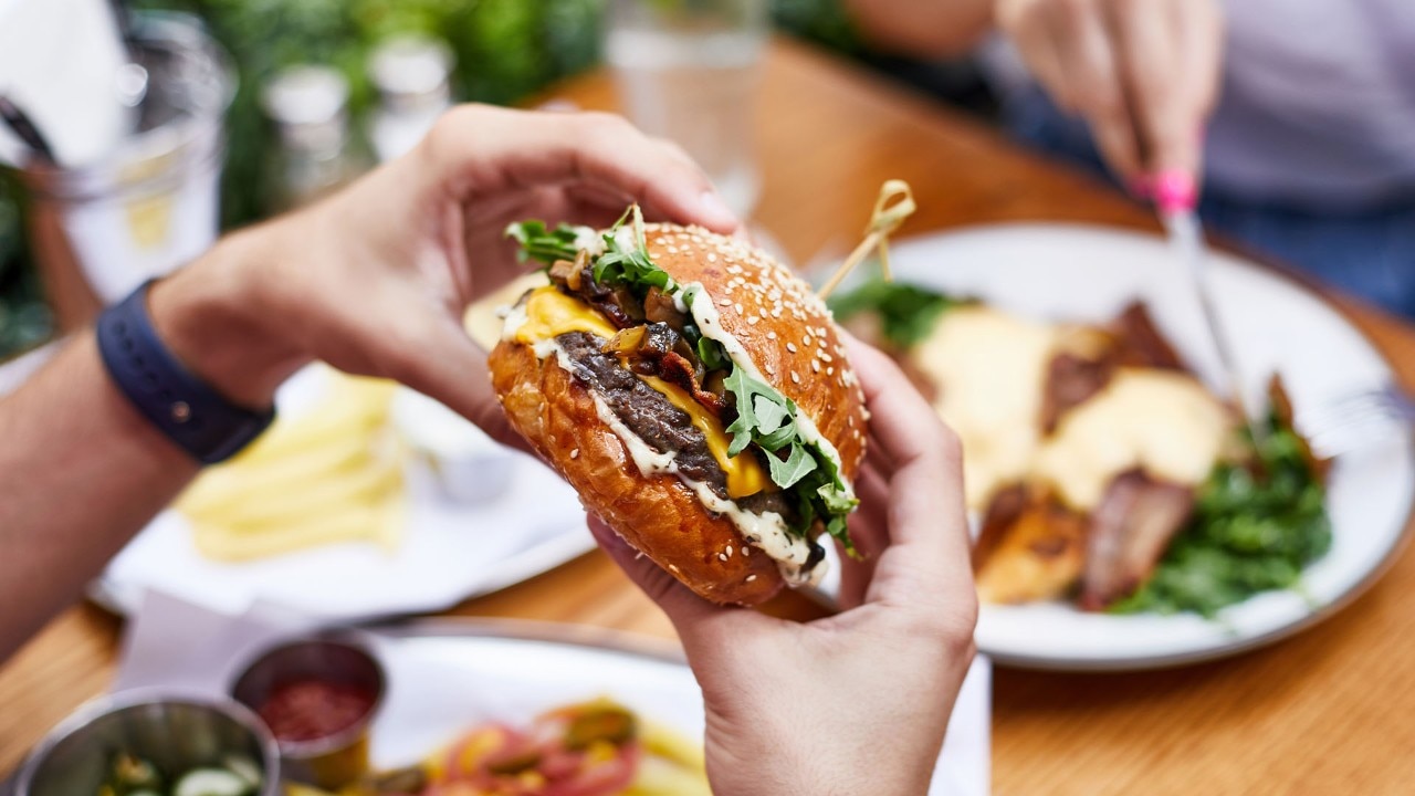 Person holding onto a burger at the best burger spots in Singapore