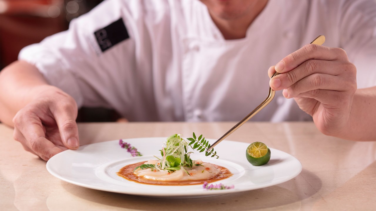 A chef plating a dish from MICHELIN starred restaurant CUT